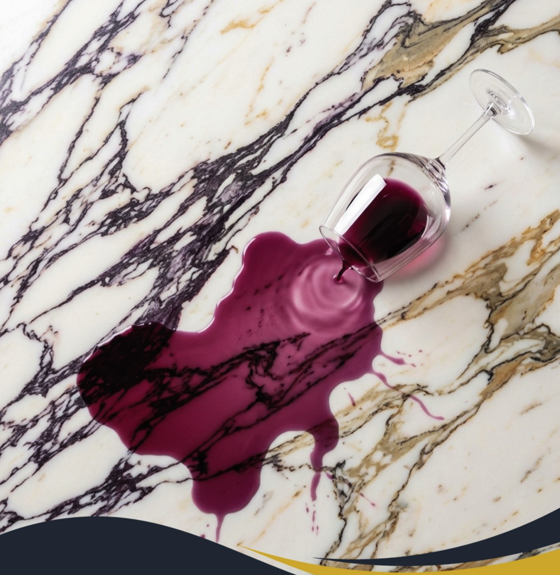 Red wine spilled from a tipped glass on Calacatta Viola marble treated with AntiEtch, beading on the sealed surface instead of etching it